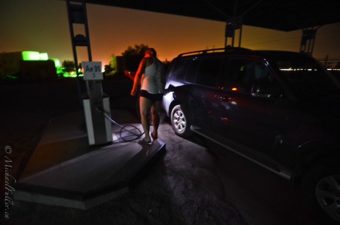 Buying fuel under-the-table, from an unofficial petrol station. Yes that attendant is in his underwear.