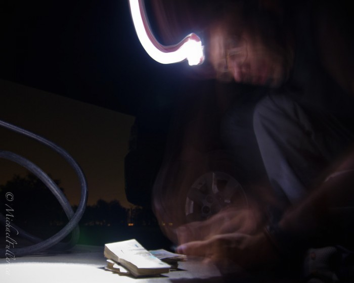 Sasha counting the brick of money required to pay for a tank of fuel.